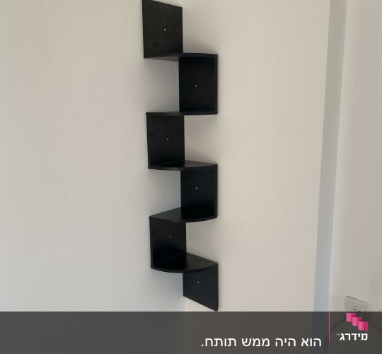 מדף פינת שחור מותקן על קיר לבן